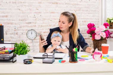 Family Business - telecommute Businesswoman and mother with kid is making a phone call clipart