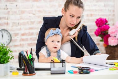 Family Business - telecommute Businesswoman and mother with kid is making a phone call clipart