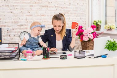 Anne ve bebek kızı ile oynamaya ve dizüstü bilgisayarınızla evde çalışma iş kadını.