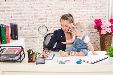 Anne ve bebek kızı ile oynamaya ve dizüstü bilgisayarınızla evde çalışma iş kadını.