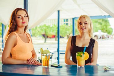 İki kız arkadaş eğlenceli yaz aylarında açık olan. Tatilde kokteyl bardak kadınlarla