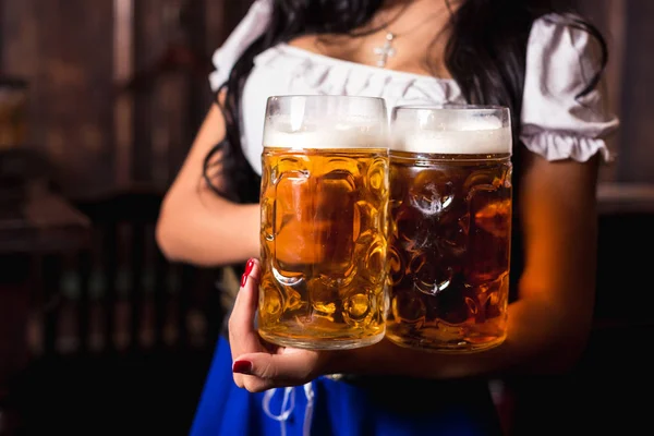 Büyük bira bardağı, hizmet veren bir geleneksel Bavyera elbise giyen genç seksi Oktoberfest garson, bar.