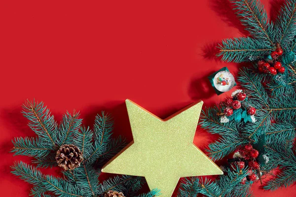 Çam kozalakları, çam dalları ve hediye kutuları kırmızı zemin üzerine yığını Noel bileşimi