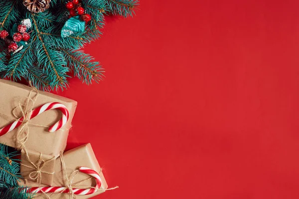 Çam kozalakları, çam dalları ve hediye kutuları kırmızı zemin üzerine yığını Noel bileşimi