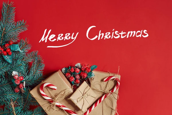 Çam kozalakları, çam dalları ve hediye kutuları kırmızı zemin üzerine yığını Noel bileşimi