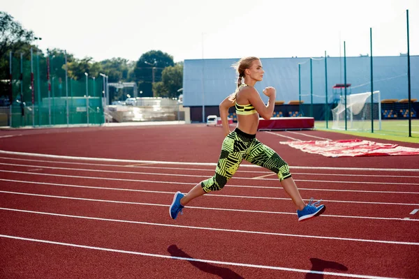 Hermosa joven ejercicio de jogging y correr en pista atlética en el estadio . — Foto de Stock