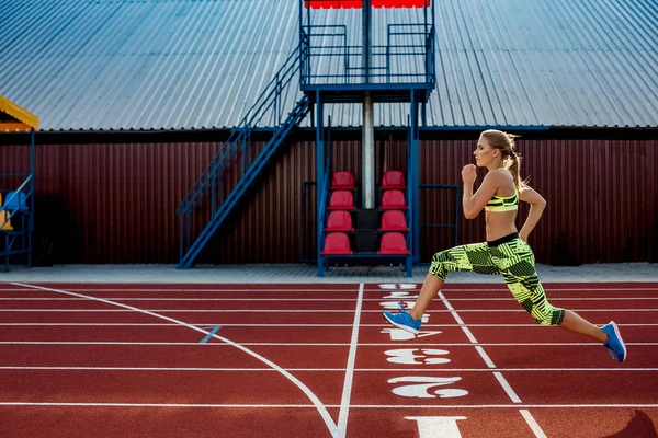 Una atleta corre a lo largo de la cinta. Fondo deportivo — Foto de Stock