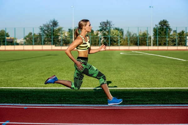 Una atleta corre a lo largo de la cinta. Fondo deportivo — Foto de Stock