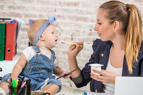 Anne ve bebek kızı ile oynamaya ve dizüstü bilgisayarınızla evde çalışma iş kadını.