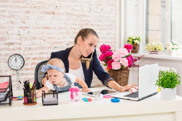 Businesswoman mother woman with a daughter working at the laptop — Stock Photo, Image