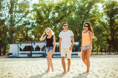 Komik gençler kumsalda güneş gözlüğü. Arkadaşlar birlikte.