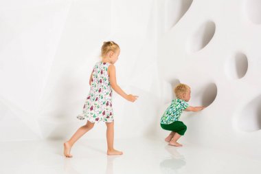 Oynama ve beyaz bir stüdyoda gülümseyen kardeş