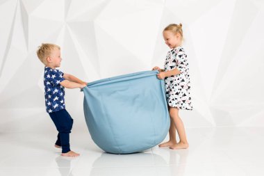 Oynama ve beyaz bir stüdyoda gülümseyen kardeş