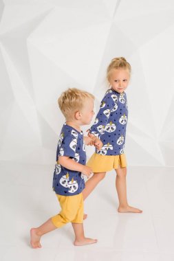 Oynama ve beyaz bir stüdyoda gülümseyen kardeş