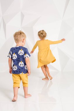 Oynama ve beyaz bir stüdyoda gülümseyen kardeş