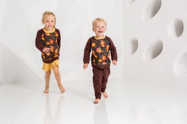 Oynama ve beyaz bir stüdyoda gülümseyen kardeş