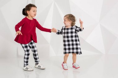 Çocuk sisters birlikte beyaz arka plan üzerinde çal