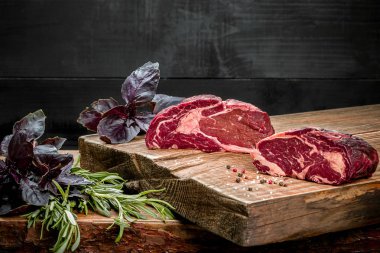 Kesme tahtası ile taze fesleğen ve biberiye fışkın taze çiğ et