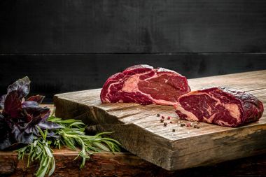 Kesme tahtası ile taze fesleğen ve biberiye fışkın taze çiğ et