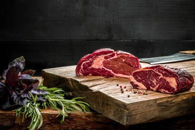 Kesme tahtası ile taze fesleğen ve biberiye fışkın taze çiğ et