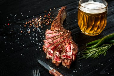 Barbekü sığır eti baharat, sebze ve light bira yakın çekim siyah ahşap zemin üzerine bir bardak kuru yaşlı kaburga