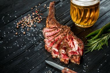 Barbekü sığır eti baharat, sebze ve light bira yakın çekim siyah ahşap zemin üzerine bir bardak kuru yaşlı kaburga