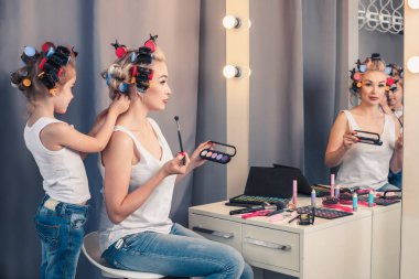 Güzel genç anne ve kızıyla birlikte saç curlers sp vardır