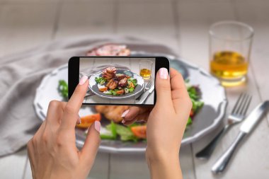 Fotoğrafçılık gıda kavramı - kadın sıcak et yemekleri resmini alır. Salata ve bir plaka üzerinde elma ile Domuz kaburga ızgara.