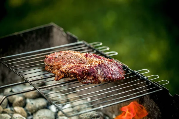 Bife picante quente grelhando em um churrasco de verão sobre as brasas quentes decoradas . — Fotografia de Stock