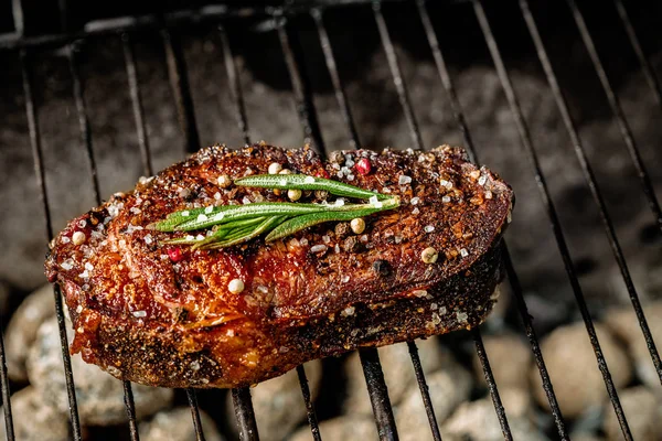 Sıcak Baharatlı biftek süslenmiş sıcak kömürlerin üzerinde bir yaz barbekü ızgara biberiye dalı ile dekore edilmiştir.