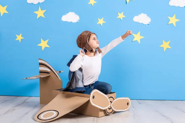 Маленька дівчинка в костюмі пілотів грає і мріє про політ над хмарами . — стокове фото