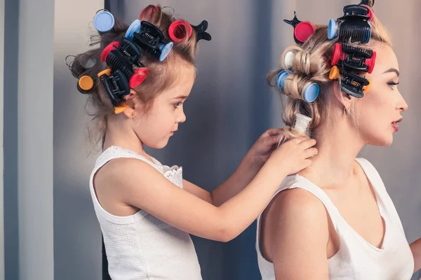 Krásná mladá matka a její dcera s kulem na vlasy — Stock fotografie