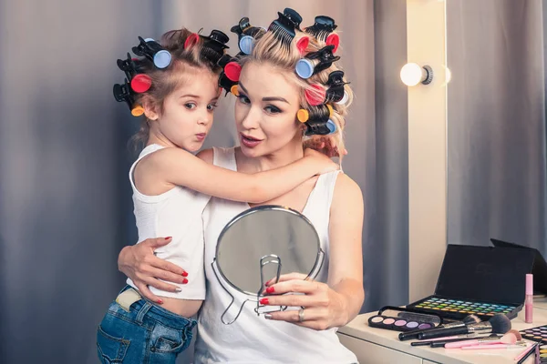 Krásná mladá matka a její dcera s kulem na vlasy jsou sp — Stock fotografie