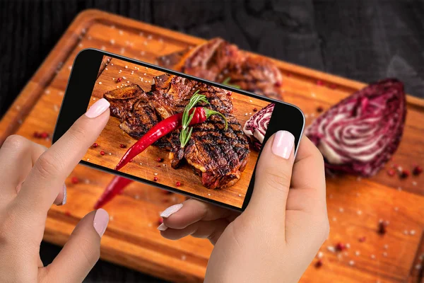 촬영 식품 개념-관광 스마트폰에 나무 보드를 절단에 준비-투-먹는 쇠고기 스테이크 접시의 그림은. — 스톡 사진