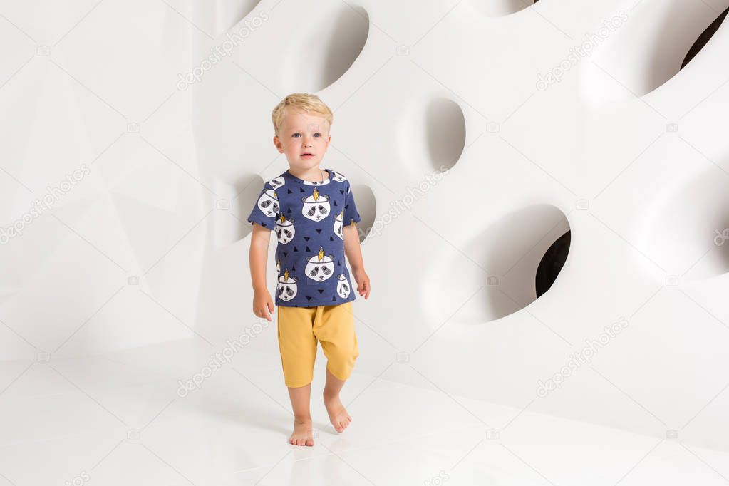 little boy in a t-shirt and shorts on a white background