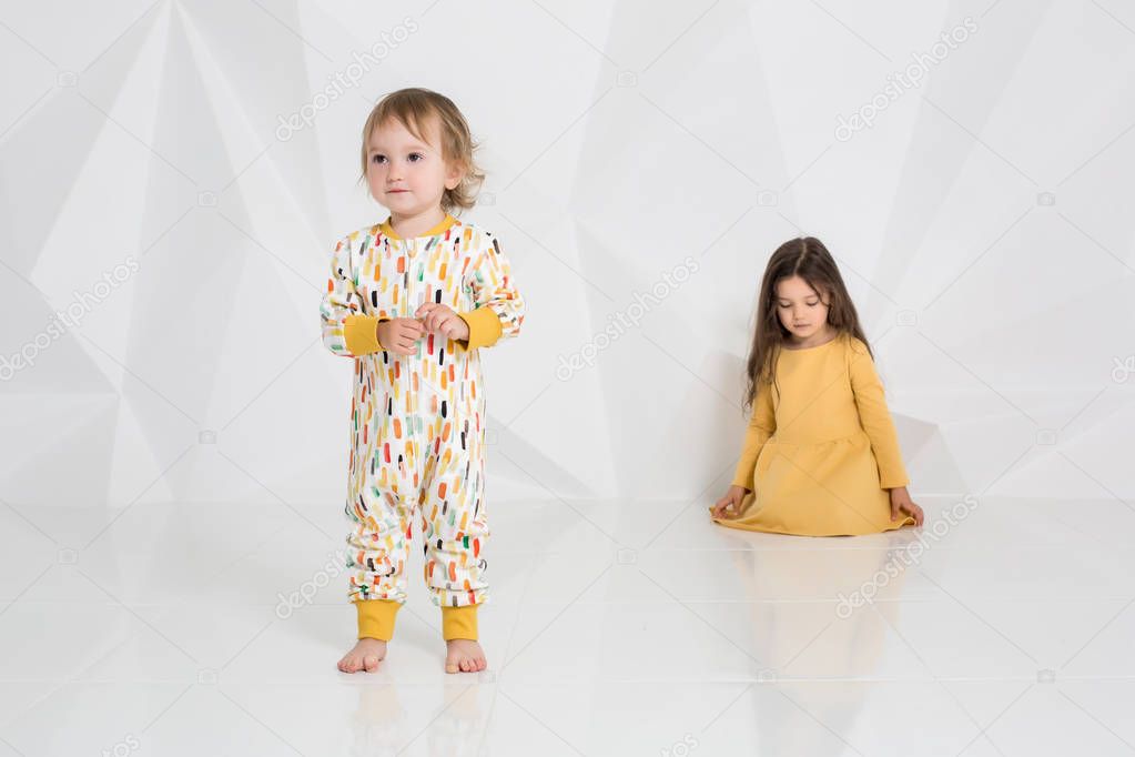 Children sisters play together on white background