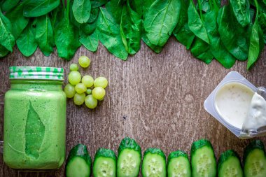 Ispanaklı karşı bir kupa ahşap arka plan üzerinde sağlıklı yeşil smoothie