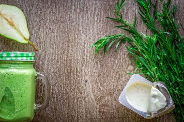 Ispanaklı karşı bir kupa ahşap arka plan üzerinde sağlıklı yeşil smoothie