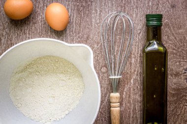 Gıda katkı maddeleri ve ahşap arka plan üzerinde yemek pişirmek için mutfak gereçleri