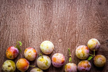 ahşap arka plan üzerinde taze sulu Erik