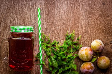 Taze erik suyu ve vintage ahşap zemin üzerine yeşil nane ile cam