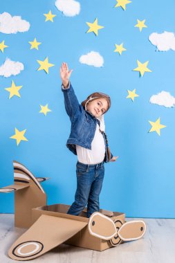 Küçük çocuk kız pilotlar kostümlü oynayan ve bulutların üzerinde uçan bir rüya.