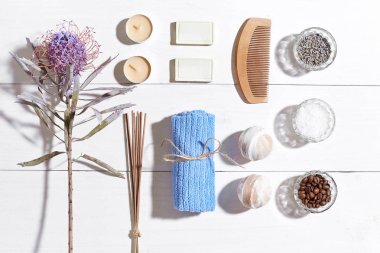 Spa Ürünleri. Banyo tuzları, kuru çiçekler lavanta, sabun, mumlar ve havlu. Düz beyaz ahşap zemin, üstten görünüm üzerinde yatıyordu.