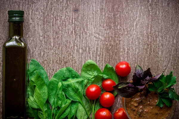 Свежие органические ингредиенты для приготовления соуса: шпинат, помидоры, ростки, базилик, оливковое масло на деревенском фоне, вид сверху . — стоковое фото