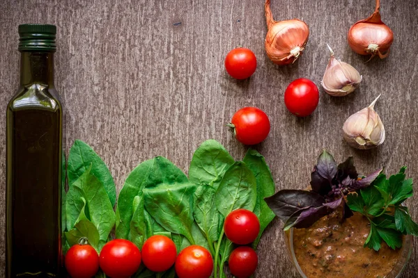 Свежие органические ингредиенты для приготовления соуса: шпинат, помидоры, ростки, базилик, оливковое масло на деревенском фоне, вид сверху . — стоковое фото