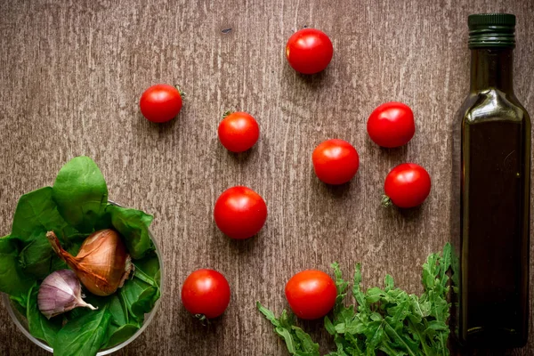 Свежие органические ингредиенты для приготовления салата: шпинат, помидоры, ростки, базилик, оливковое масло на деревенском фоне, вид сверху . — стоковое фото