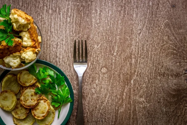 Karnabahar ve meyilli ahşap arka plan üzerinde pişmiş kabak.