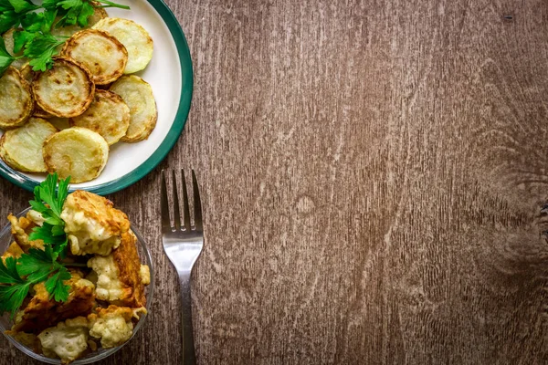 Karnabahar ve meyilli ahşap arka plan üzerinde pişmiş kabak.