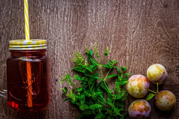 Taze erik suyu ve vintage ahşap zemin üzerine yeşil nane ile cam