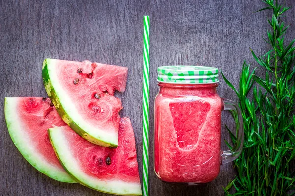 Watermeloen smoothie en segmenten op donkere houten achtergrond. Plat lag of bovenste weergave. — Stockfoto